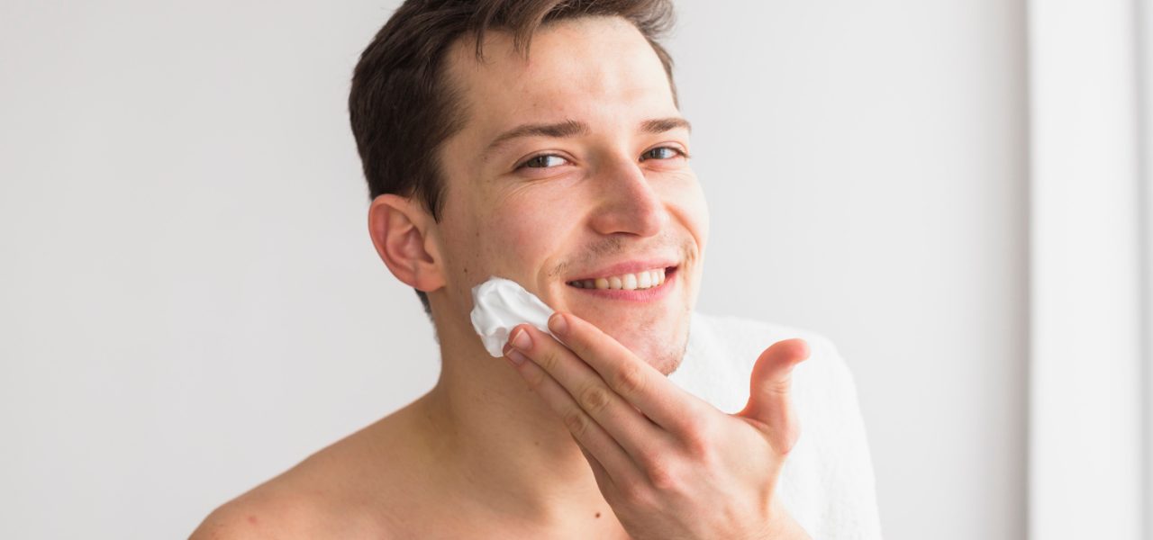 man putting moisturiser