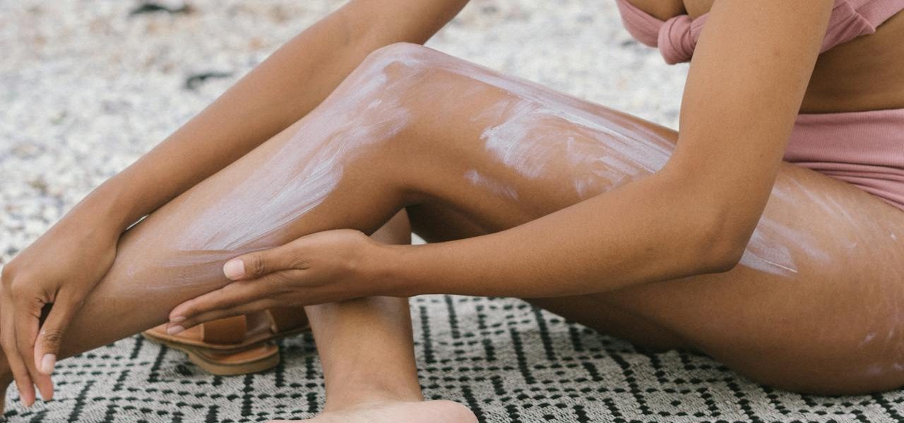 woman putting sunscreen on her body